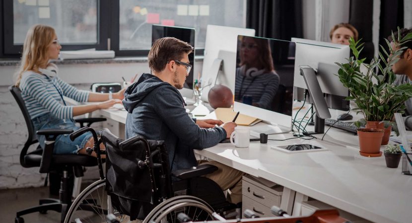 man in wheelchair working in the office