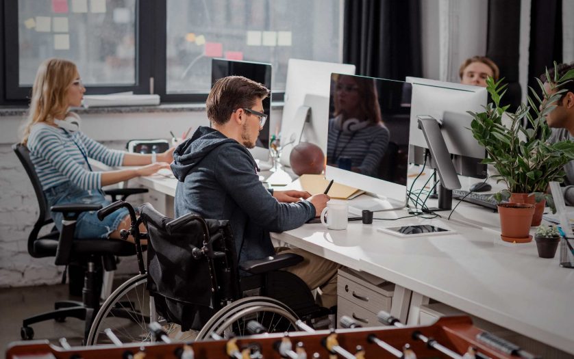man in wheelchair working in the office