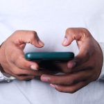 Close up of young man hand using smartphone