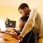 Close up portrait of young african boy using computer