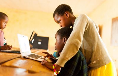 Close up portrait of young african boy using computer