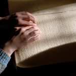Blind person reading text in braille