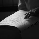 blind person reading a braille book