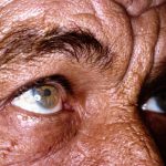 Close up of old man eyes, sun burned and wrinkled skin
