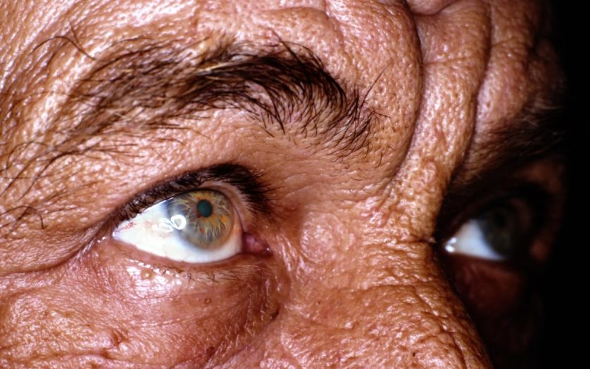 Close up of old man eyes, sun burned and wrinkled skin
