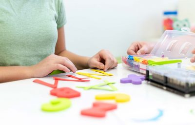 Therapist helping teenage girl with learning difficulties during child therapy