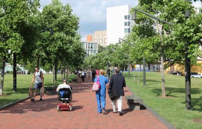 Wheelchair user and people walk in campus of Pennsylvania State University in Philadelphia.