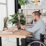 man in wheelchair using laptop