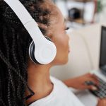 woman listening audiobooks on laptop