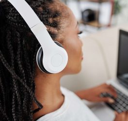 woman listening audiobooks on laptop