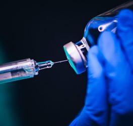 Vaccine shot drug needle syringe on black background