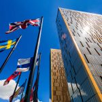 The two towers of the European Court of Justice and flag poles in Luxembourg against blue sky