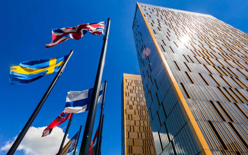 The two towers of the European Court of Justice and flag poles in Luxembourg against blue sky