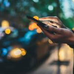 Traveler woman calling mobile phone waiting yellow taxi in evening street europe city Barcelona.