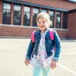Portrait child girl with disability outside on a school playground