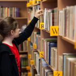 Young girl in library looking for books