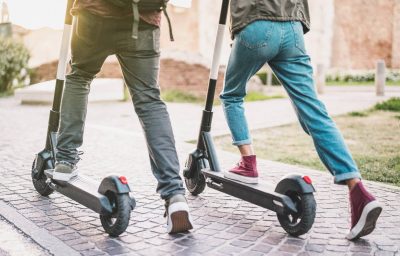 Close up of people using electric scooter in street