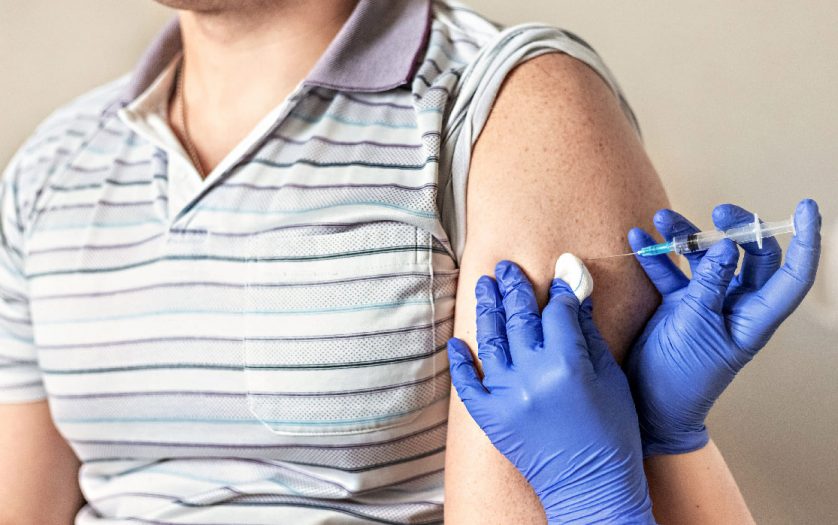 A doctor vaccinates a man against coronavirus at a clinic.