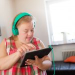 Woman with down syndrome using digital tablet