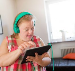 Woman with down syndrome using digital tablet