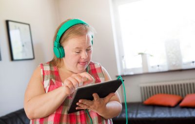 Woman with down syndrome using digital tablet
