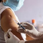 vaccine for covid-19 is being given to an Indian woman wearing mask
