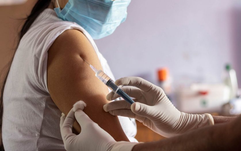 vaccine for covid-19 is being given to an Indian woman wearing mask