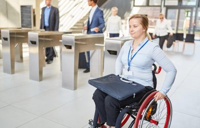 woman in a wheelchair past the security gate in the office