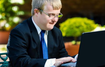 Close up portrait of businessman with down syndrome working.