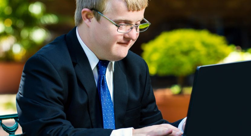 Close up portrait of businessman with down syndrome working.