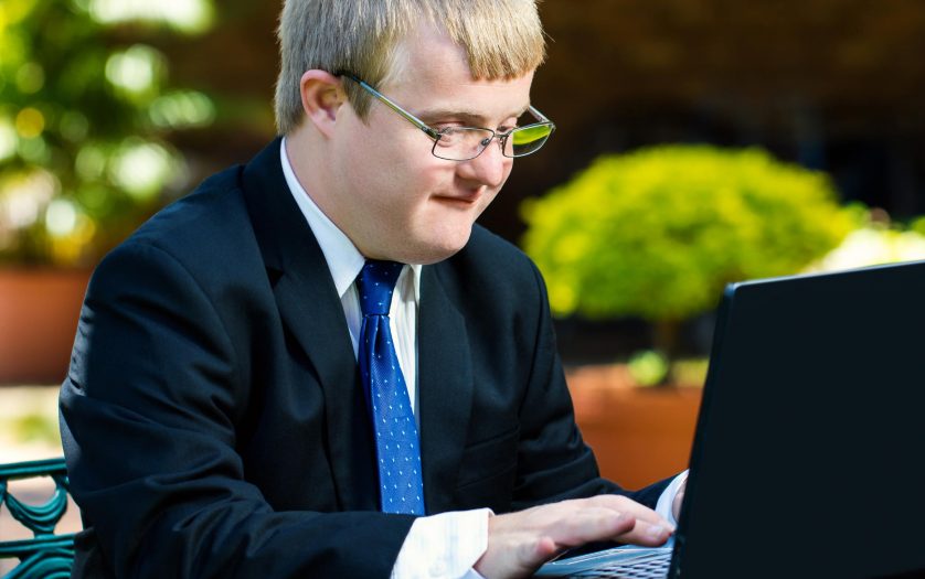 Close up portrait of businessman with down syndrome working.