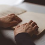 blind person reading braille book