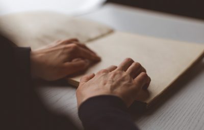 blind person reading braille book