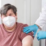 woman with disability is getting a vaccination from a male doctor