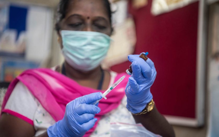 A medical worker prepare an injection of vaccine during a vaccination drive at a community healthcare center.