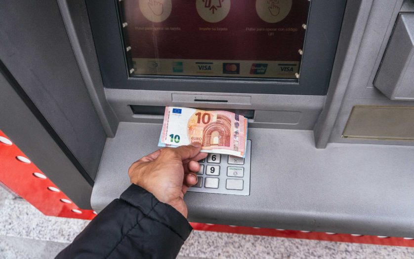 Man`s hand takes out cash euros from Santander Bank in Madrid, Spain