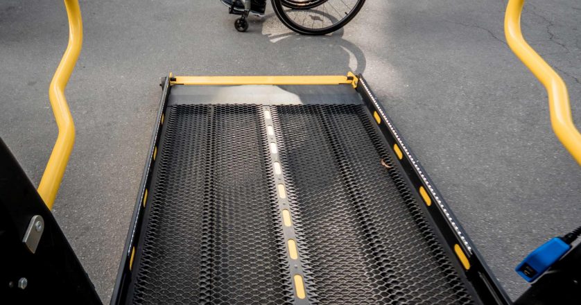 A man in a wheelchair moves to the lift of an accessible bus