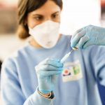 Nurse loading syringe with vaccine.