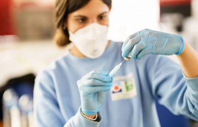 Nurse loading syringe with vaccine.