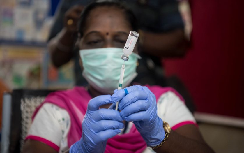 A medical worker prepare an injection of vaccine during a vaccination drive at a community healthcare center.