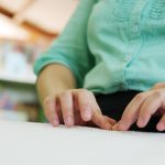Close-up of blind person woman hands reading Braille