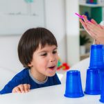 toddler doing tests with plastic cups