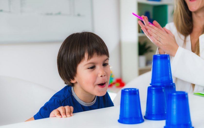 toddler doing tests with plastic cups