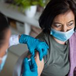 A top view of senior woman getting vaccinated in hospital