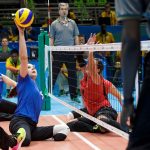 women sitting on the floor and playing volleyball