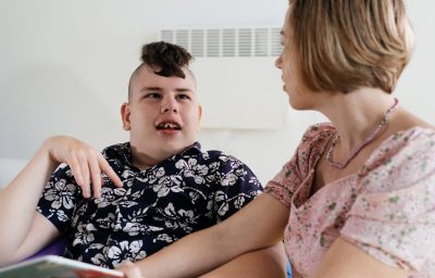 Cerebral palsy boy talking with woman