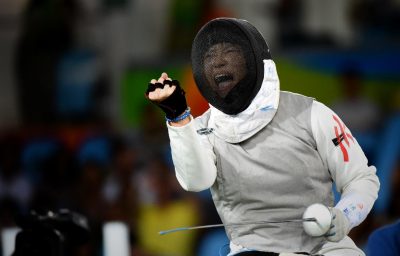 Women in wheelchair celebrating her victory in wheelchair fencing