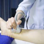 Skillful sonographer using ultrasound machine in hospital for diagnosis at left leg for finding posterior tibial vein suspected deep vein thrombosis