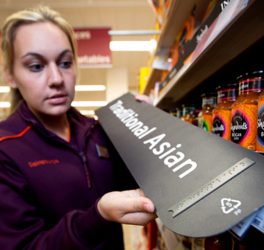 Lady at Sainsbury's store showing Braille signage exemplar.