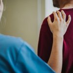 Female nurse touching a patients shoulder
